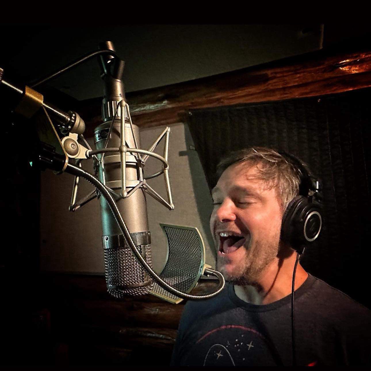Eric Treehouse singing into a microphone in the studio